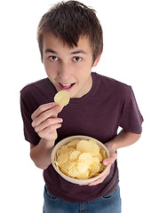 Image showing Boy eating chip snack and looking up