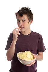 Image showing Boy eating potato crisps