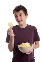 Image showing Boy holding potato crisp and smiling