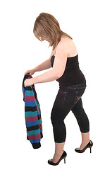 Image showing Girl folding her jacket.    