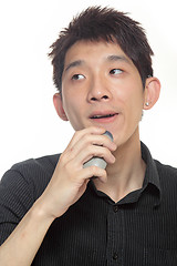 Image showing young man shaving his beard off with an electric shaver 