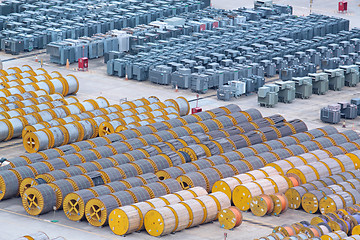 Image showing electricity cable on wooden spools and many transformer on the f
