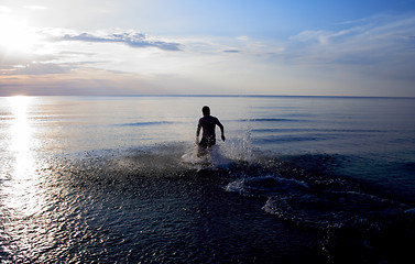 Image showing Man standing in sea at late evening