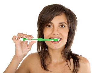 Image showing Young woman brushing her teeth