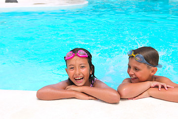 Image showing Happy children,  girl and boy, relaxing on the side of a swimmin