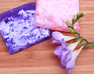 Image showing Lilac and pink soap on wooden background in a spa composition 