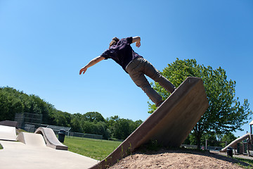 Image showing Skateboarder Riding Up a Concrete Skate Ramp