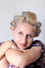 Image showing  young woman with hair curlers on her head. 