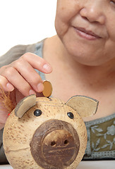 Image showing woman putting coins in small piggy bank. Selective focus, Copy s