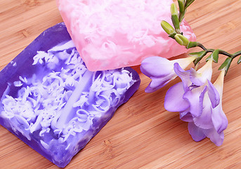 Image showing Lilac and pink soap on wooden background in a spa composition 