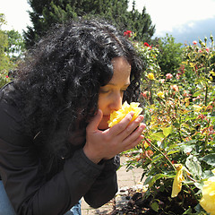 Image showing Pretty brunette smelling roses