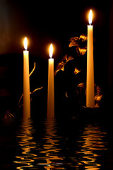 Image showing Candles and its reflection in dark water