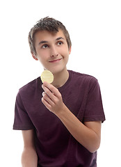 Image showing Boy with potato crisp looking sideways