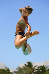 Image showing boy jumping into the pool smiling 