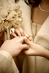 Image showing puttting on a wedding ring. stylized photo