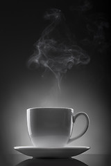 Image showing white cup with hot liquid and steam on black