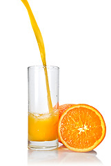 Image showing orange juice poring into glass isolated on white