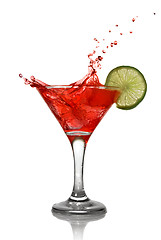 Image showing Red cocktail with splash and lime isolated on white