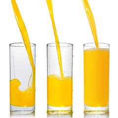 Image showing orange juice poring into glass isolated on white