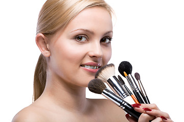 Image showing Young smiling woman with make up brushes isolated on white