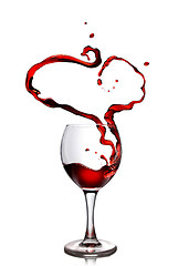 Image showing Heart from pouring red wine in goblet isolated on white