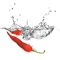 Image showing red pepper dropped into water with splash isolated on white