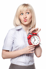 Image showing A beautiful young woman with alarm clock isolated on white