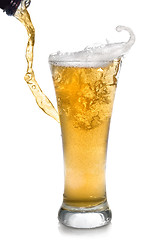 Image showing Beer pouring from bottle into glass isolated on white