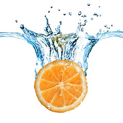 Image showing Fresh lemon dropped into water with splash isolated on white