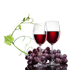 Image showing Red wine in glasses with grape and rod isolated on white