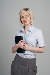 Image showing Young attractive businesswoman holding diary isolated on grey