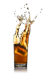 Image showing Beautiful splash of cola with ice in glass isolated on white