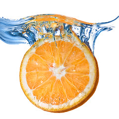 Image showing Fresh orange dropped into water with splash isolated on white