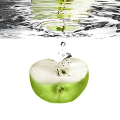 Image showing green apple dropped into water with bubbles isolated on white