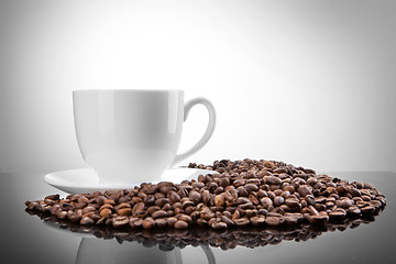 Image showing white cup with coffee beans on white 