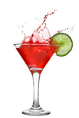 Image showing Red cocktail with splash and lime isolated on white