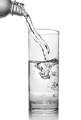 Image showing water pouring into glass from bottle isolated on white