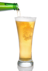 Image showing Beer pouring from bottle into glass isolated on white