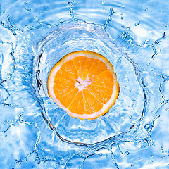 Image showing Fresh orange dropped into water with bubbles isolated on white