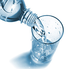 Image showing water pouring into glass from bottle isolated on white