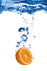 Image showing Fresh orange dropped into water with bubbles isolated on white