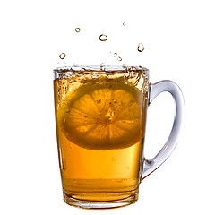 Image showing lemon dropped into tea cup with splash and reflection isolated o