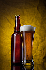 Image showing Beer in glass with bottle on yellow background