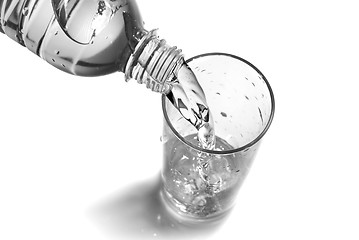 Image showing water pouring into glass from bottle isolated on white