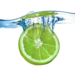 Image showing Fresh lime dropped into water with splash isolated on white