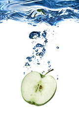 Image showing green apple dropped into water with bubbles isolated on white