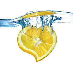 Image showing heart from lemon dropped into water isolated on white