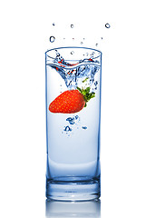 Image showing Strawberry dropped into water glass with splash isolated on whit