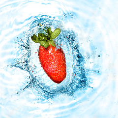 Image showing Strawberry dropped into blue water with splash. Top view