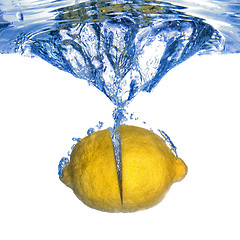 Image showing Fresh lemon dropped into water with bubbles isolated on white